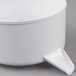 A white plastic bowl with a handle on top.