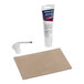 A white tube of Amana Antenna Motor glue with a red and blue label next to a piece of cardboard.