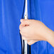 A hand using a zipper to close a blue Curtron Insul-Cover for a bun pan rack.