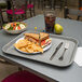 A Carlisle standard plastic fast food tray with a sandwich and chips on it.