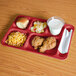 A red Cambro compartment tray with food on it.