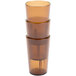 A stack of three Cambro amber plastic tumblers.