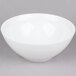 An Arcoroc white bowl with a white rim on a gray background.