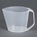 A clear plastic Rubbermaid measuring cup with a handle.