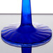 A Fineline plastic martini glass with a cobalt blue stem on a table.