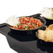 A Cal-Mil black step bowl with tortilla chips and salsa on a table.