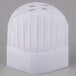 A close-up of a white Royal Paper disposable chef hat with holes in it.