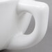 A close up of a Tuxton white china cappuccino cup with a handle.