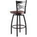 A Lancaster Table & Seating black cross back swivel bar stool with a wooden seat.