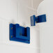 A blue and white Choice wall-mount bracket holding an ice bucket on a white tile wall.
