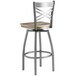 A Lancaster Table & Seating metal cross back bar stool with a wooden seat.