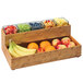 A Cal-Mil Madera wood stacking box full of oranges, red apples, and bananas.