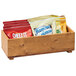 A Cal-Mil Madera wood stacking box on a counter filled with different types of snacks.