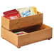 A wooden Cal-Mil stacking box filled with snacks on a counter.