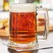 A Libbey glass mug of beer on a table.