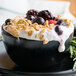 A bowl of yogurt with 10 lb. IQF frozen mixed berries and oat flakes.