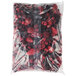 A plastic bag of red berries with white dots.