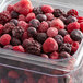 A plastic container of 10 lb. IQF frozen mixed berries.