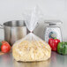 A bag of Little Barn Noodles Homemade Pot Pie Squares on a white counter next to vegetables and a pot.
