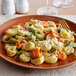 A plate of Seviroli tricolor cheese tortellini with vegetables.