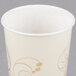 A Solo Symphony white paper cold cup with gold swirl designs.
