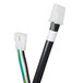 A close-up of a black and white cable with a green connector.