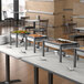 A buffet setup with several stainless steel chafing dishes on black metal stands, each containing different types of food, arranged on a white table in a restaurant setting.