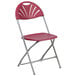 A burgundy Flash Furniture plastic folding chair with a metal frame.