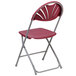 A Flash Furniture Hercules burgundy folding chair with a metal frame and folding seat.