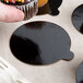A hand holding a cupcake with a black and brown Enjay dessert board.