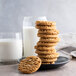 A stack of Keebler oatmeal cookies on a plate with a glass of milk.