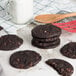 Preformed double chocolate chip cookies on a white surface.