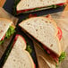 Sliced Bakery de France Sourdough bread in a sandwich with lettuce and tomato.