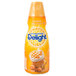 A yellow plastic bottle of International Delight Caramel Macchiato coffee creamer with blue and white text.