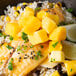 A plate of food with rice, black beans, and mango chunks.