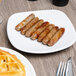 A plate of Hatfield Chef Signature pork sausage finger links and waffles on a table.