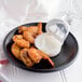 A plate of shrimp with Ken's Tartar Sauce dipping cups.