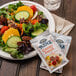 A plate of salad with a Ken's Country French dressing packet on a table in a salad bar.