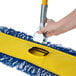 A person using a Lavex all-in-one microfiber mop to clean a floor.
