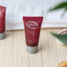 A group of small red Noble Eco Novo Natura shampoo bottles with white text.