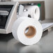 A roll of toilet paper next to a Tor Rey scale label printer.