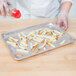 A chef in a white coat uses a Garde heavy-duty French fry cutter to make a tray of fries.