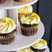 A white Enjay 5-tier cupcake stand with cupcakes on it.