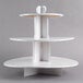 A white three tiered Enjay cupcake stand on a table in a bakery display.