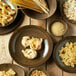 A table with Oneida Rustic Chestnut porcelain bowls filled with pasta.