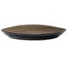 A black porcelain plate with a brown rim on a table.