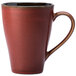 A crimson porcelain mug with a brown handle.