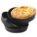 A stack of black Matfer Bourgeat tartlet pans with a pie inside one.