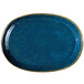 A blue oval porcelain platter with speckled blue accents and a gold rim.