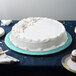 A white cake on a blue Enjay round cake drum.
